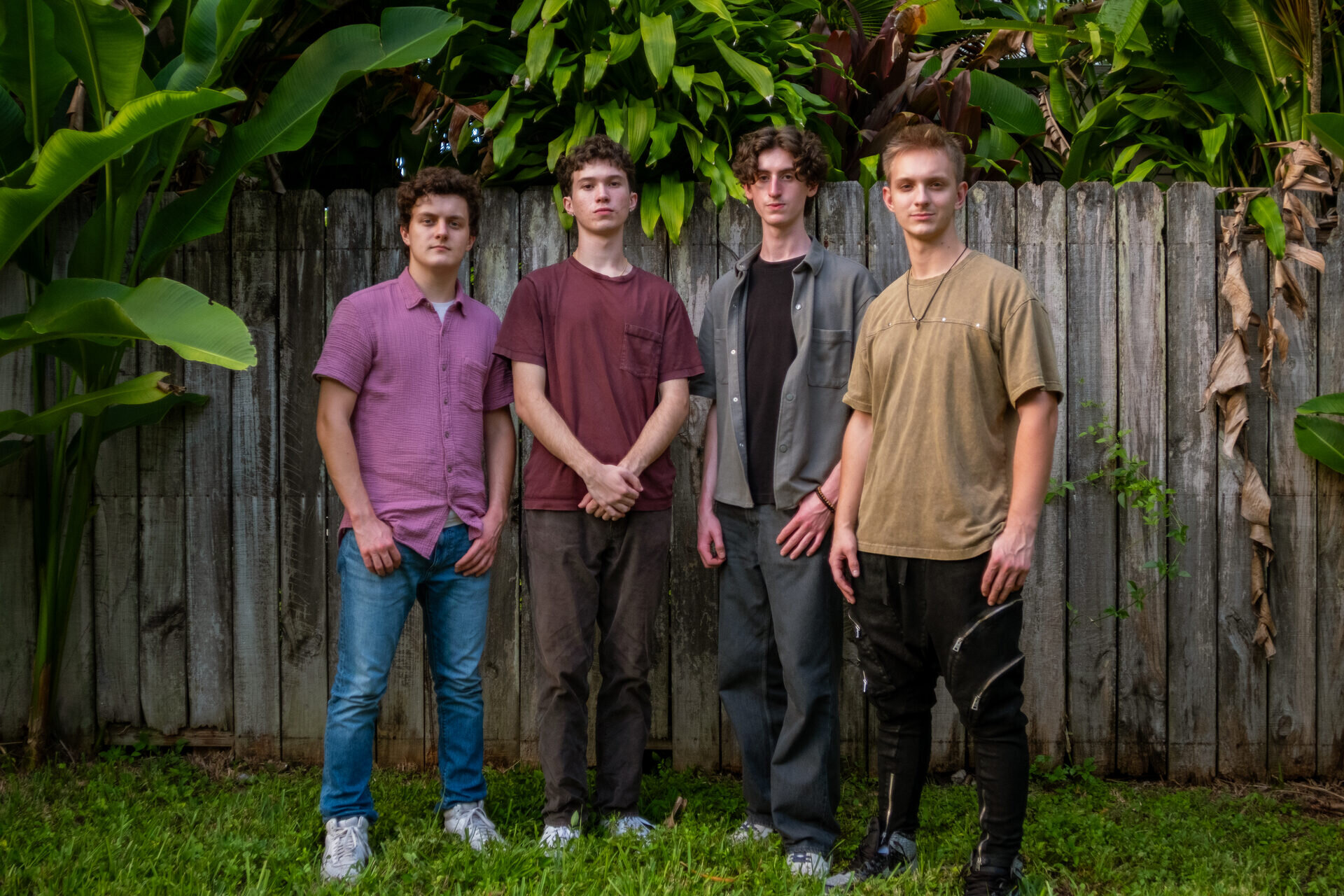 The NuSonics band standing in front of a wooden fence